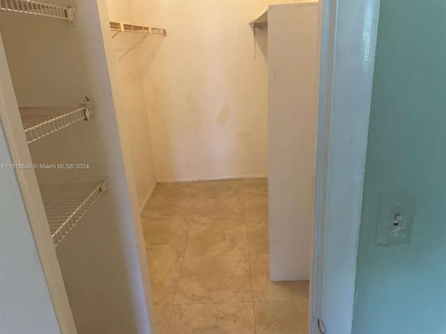 spacious closet with light tile patterned floors