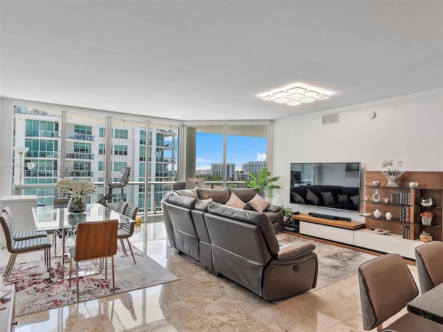 living room featuring a wall of windows and light tile patterned floors