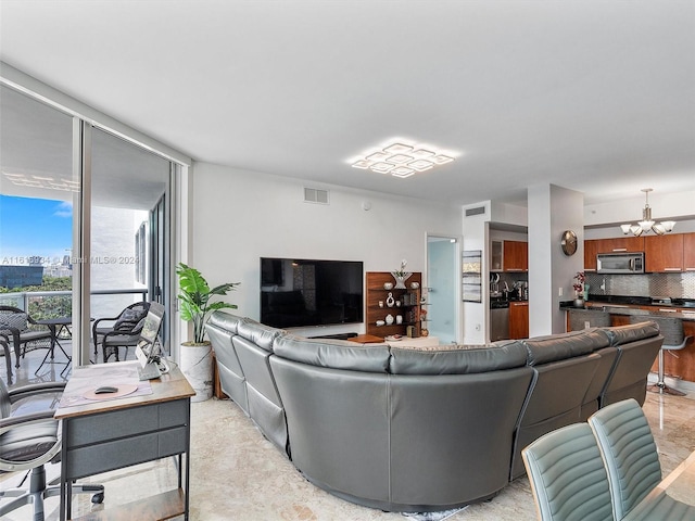 living room featuring a wall of windows and an inviting chandelier