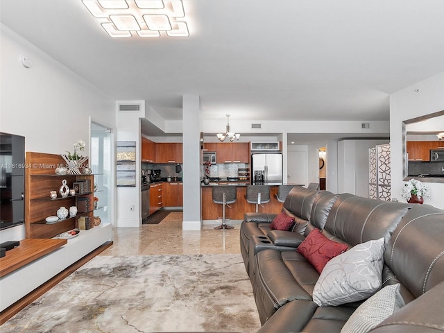 tiled living room featuring a notable chandelier