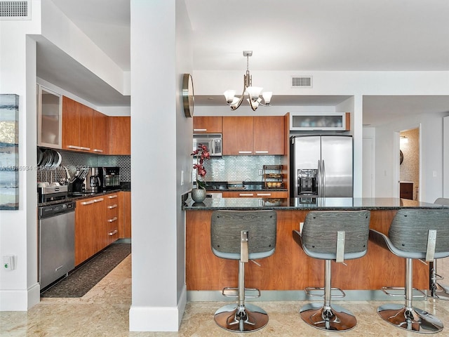 kitchen featuring decorative light fixtures, stainless steel appliances, a kitchen breakfast bar, and decorative backsplash