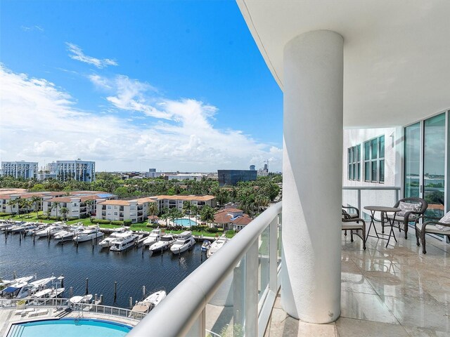 balcony featuring a water view and a community pool