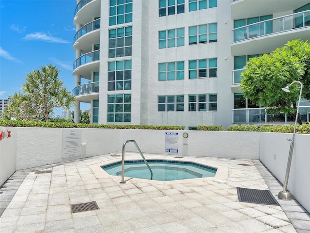 view of swimming pool with a hot tub