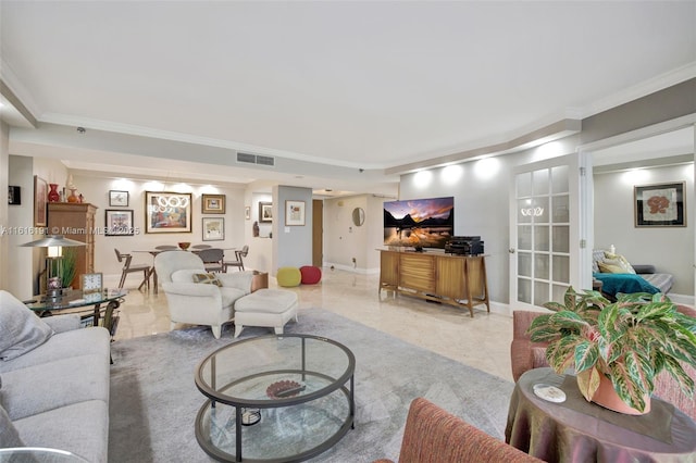 living room with ornamental molding, visible vents, and baseboards