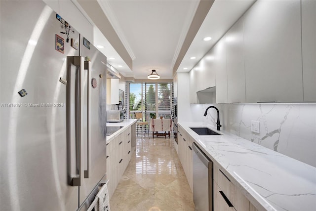 kitchen with stainless steel appliances, tasteful backsplash, a sink, and modern cabinets