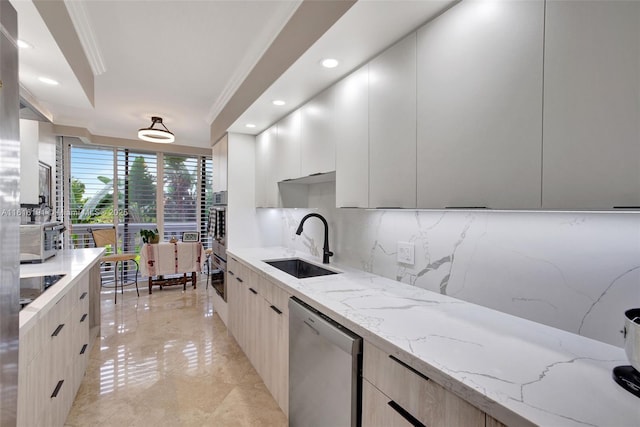 kitchen featuring stainless steel appliances, a sink, light stone countertops, modern cabinets, and crown molding