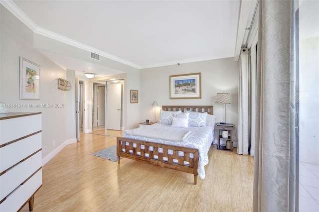 bedroom with light wood finished floors, baseboards, visible vents, and crown molding