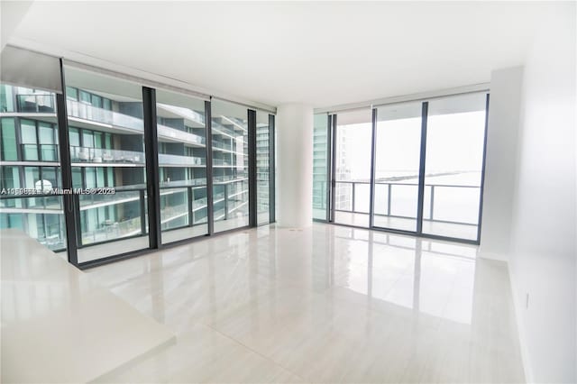 tiled empty room featuring expansive windows