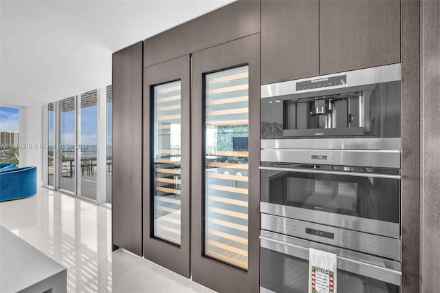 kitchen with floor to ceiling windows, double oven, and dark brown cabinets