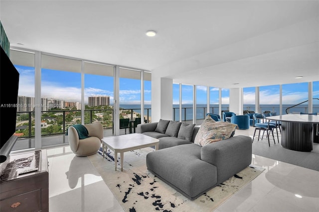 living room featuring a wall of windows, plenty of natural light, and a water view