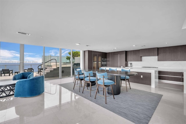 dining area with floor to ceiling windows and a water view