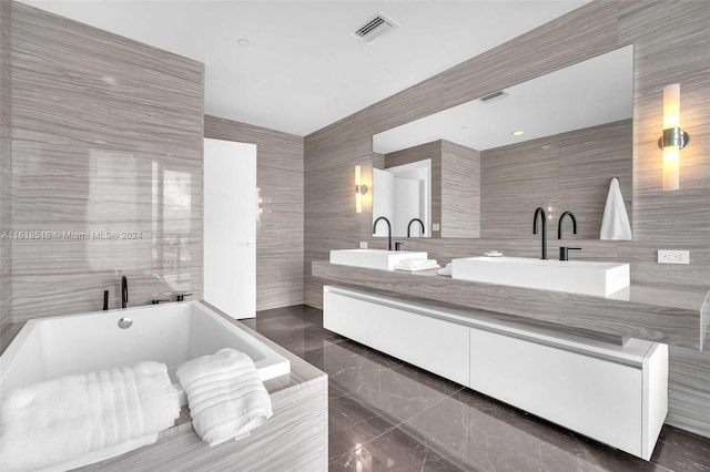 bathroom featuring tile walls, vanity, and a bath