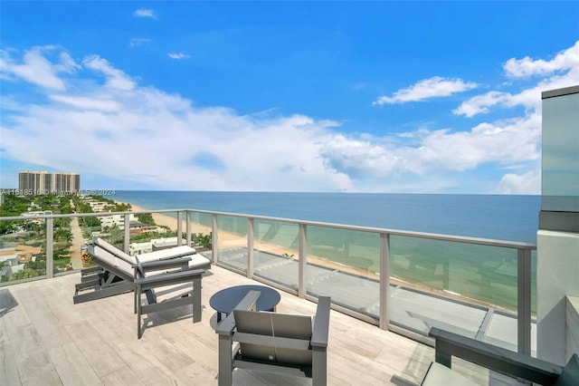 balcony with a view of the beach, outdoor lounge area, and a water view