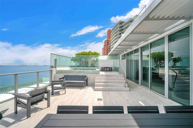 wooden terrace with a water view and outdoor lounge area