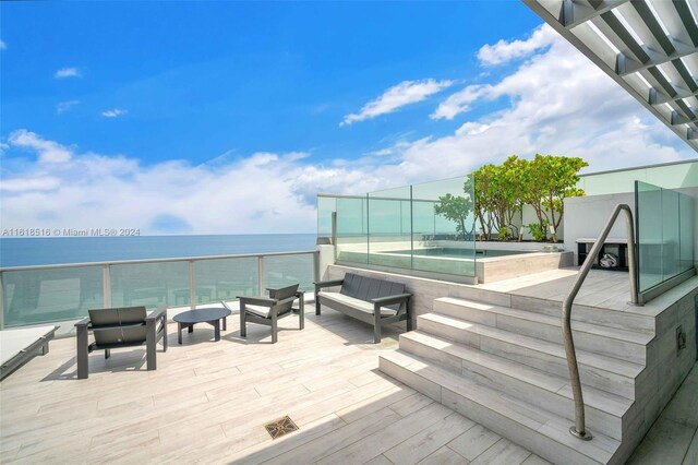 wooden terrace with a water view and outdoor lounge area