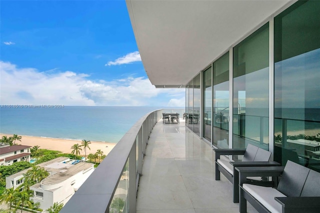 balcony featuring a water view and a beach view