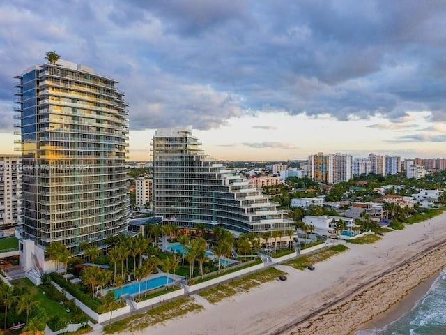 outdoor building at dusk with a water view and a view of the beach