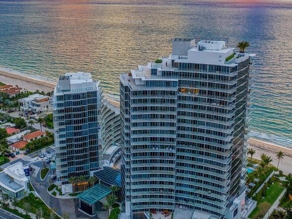 bird's eye view with a water view and a beach view