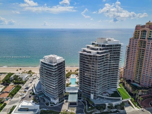 birds eye view of property with a water view and a beach view