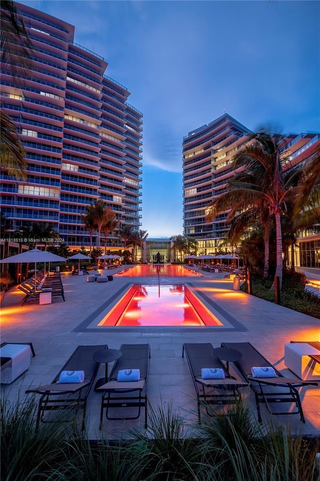 pool at dusk with a patio area