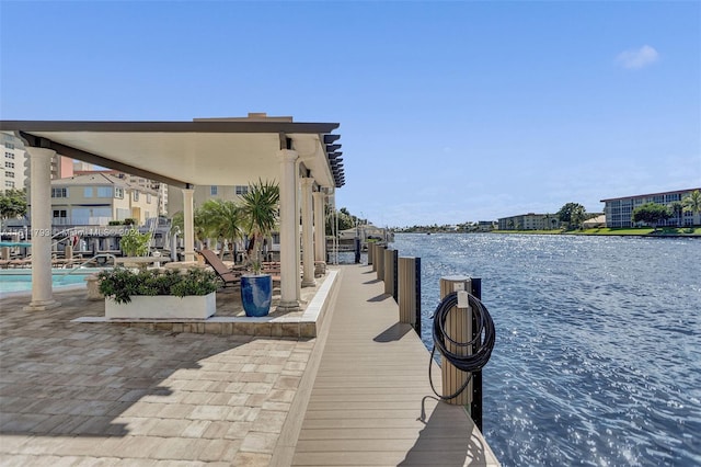 view of dock with a water view and a community pool