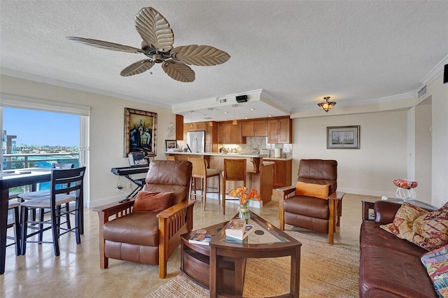 tiled living room with a textured ceiling, crown molding, and ceiling fan