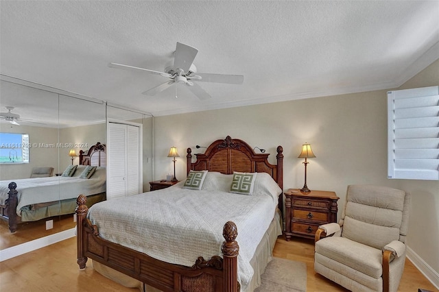 bedroom featuring light hardwood / wood-style flooring, a closet, a textured ceiling, and ceiling fan