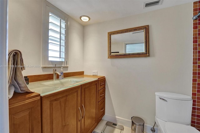 bathroom featuring vanity, tile patterned flooring, and toilet