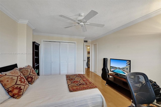 bedroom featuring a closet, wood-type flooring, ceiling fan, crown molding, and a textured ceiling