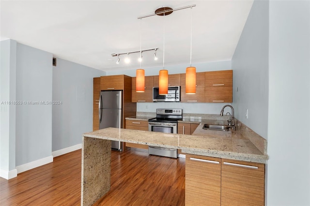 kitchen with sink, appliances with stainless steel finishes, kitchen peninsula, and a breakfast bar