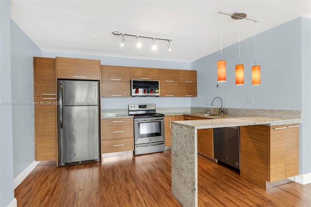 kitchen featuring appliances with stainless steel finishes, dark hardwood / wood-style flooring, and kitchen peninsula