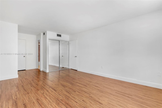 unfurnished bedroom featuring a closet and light wood-type flooring