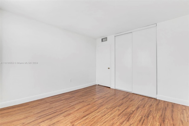 unfurnished bedroom with light hardwood / wood-style floors and a closet