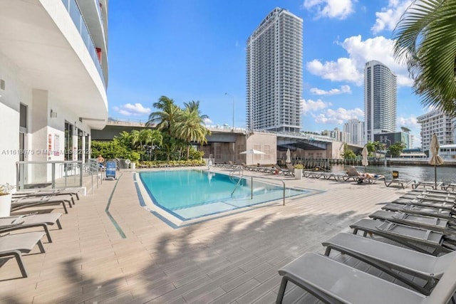 view of pool featuring a water view and a patio area