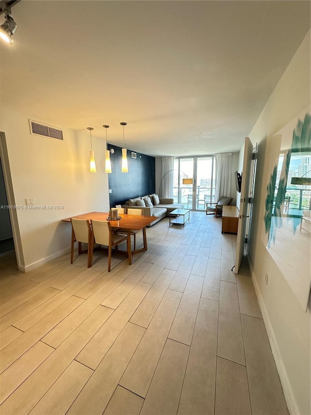 dining area featuring a wall of windows and light hardwood / wood-style flooring