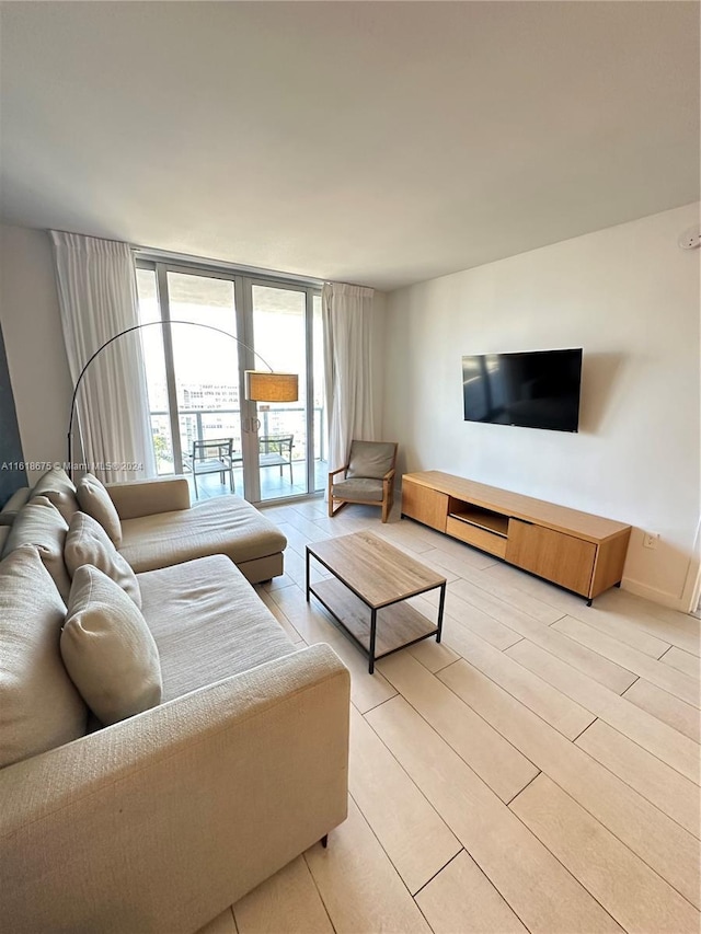 living room featuring floor to ceiling windows and light hardwood / wood-style flooring