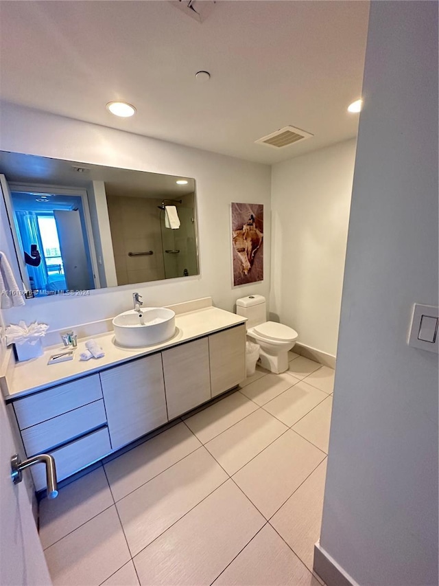 bathroom with tile patterned flooring, vanity, walk in shower, and toilet