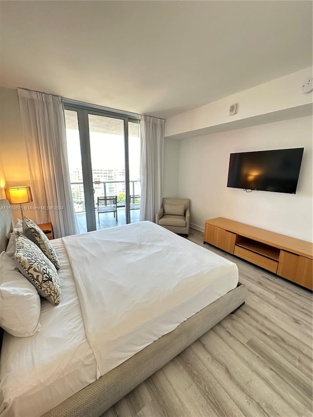 bedroom featuring floor to ceiling windows, access to outside, and light wood-type flooring