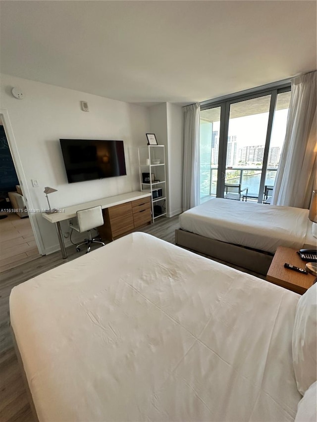 bedroom with wood-type flooring and access to outside