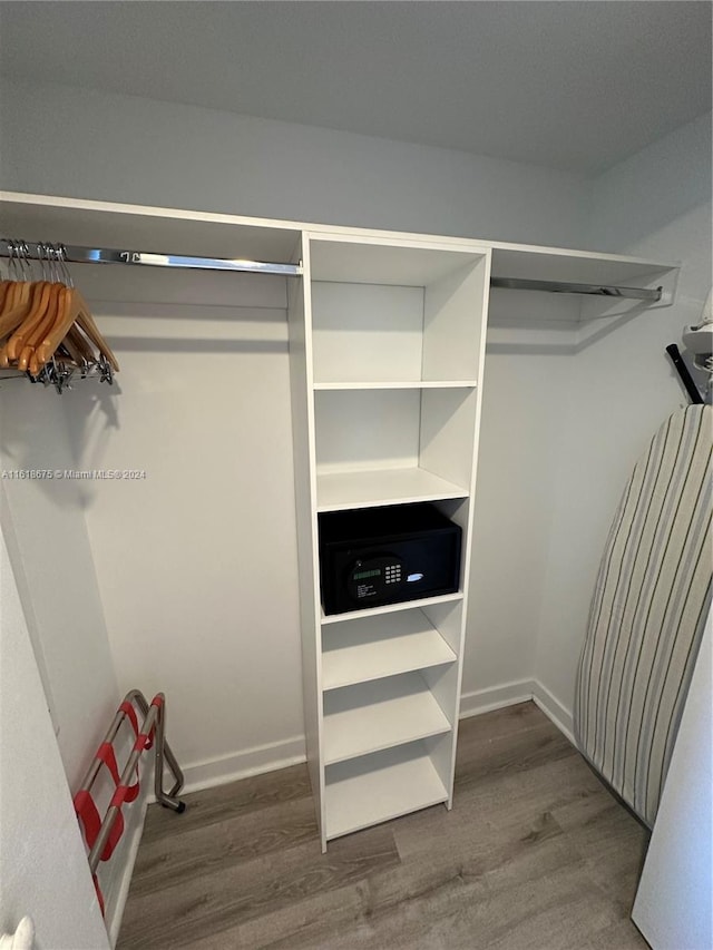 walk in closet with hardwood / wood-style flooring