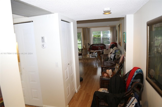 corridor featuring hardwood / wood-style flooring and a textured ceiling