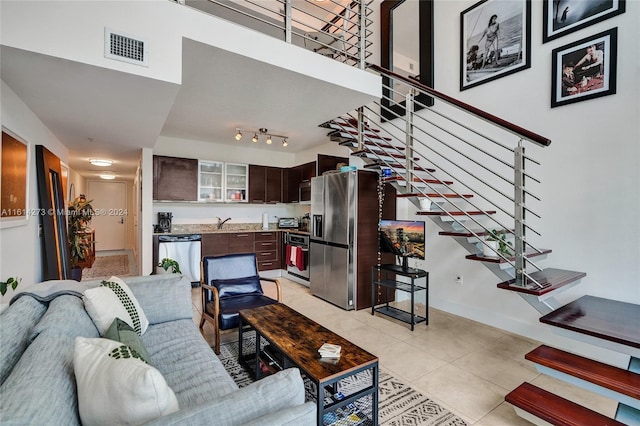 tiled living room featuring sink and track lighting