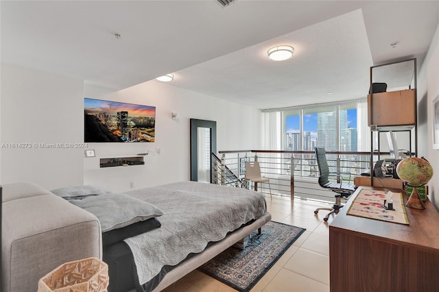 bedroom featuring light tile patterned flooring and expansive windows