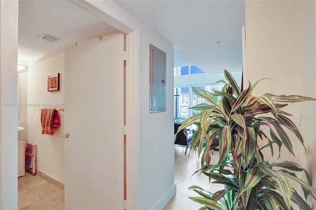 hallway featuring electric panel and tile patterned flooring