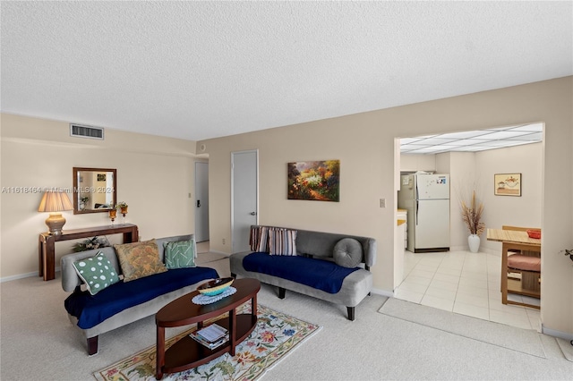 living room with a textured ceiling and light tile patterned floors