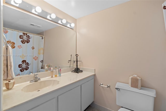 bathroom featuring toilet, vanity, and walk in shower