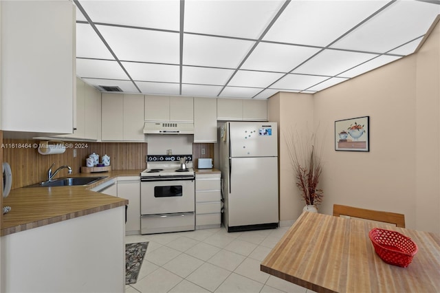 kitchen with white cabinets, white electric range, sink, fridge, and light tile patterned floors