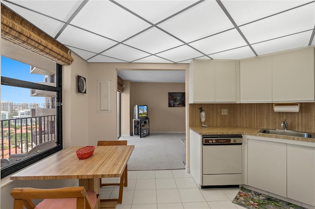 kitchen featuring dishwasher, light carpet, tasteful backsplash, sink, and cream cabinetry