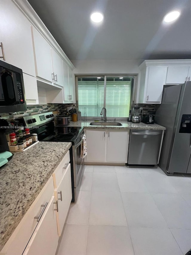 kitchen featuring white cabinetry, light tile patterned floors, backsplash, stainless steel appliances, and sink