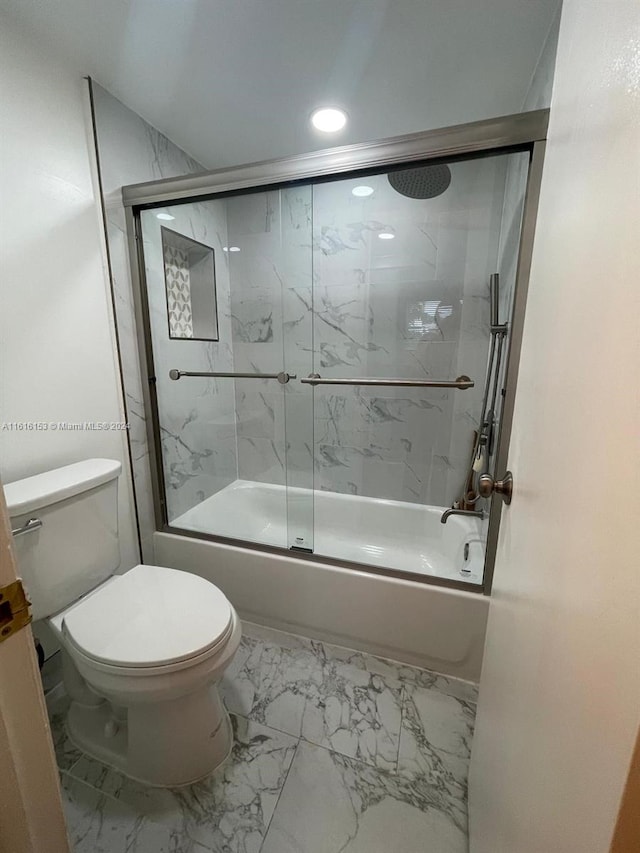 bathroom with combined bath / shower with glass door, tile patterned floors, and toilet